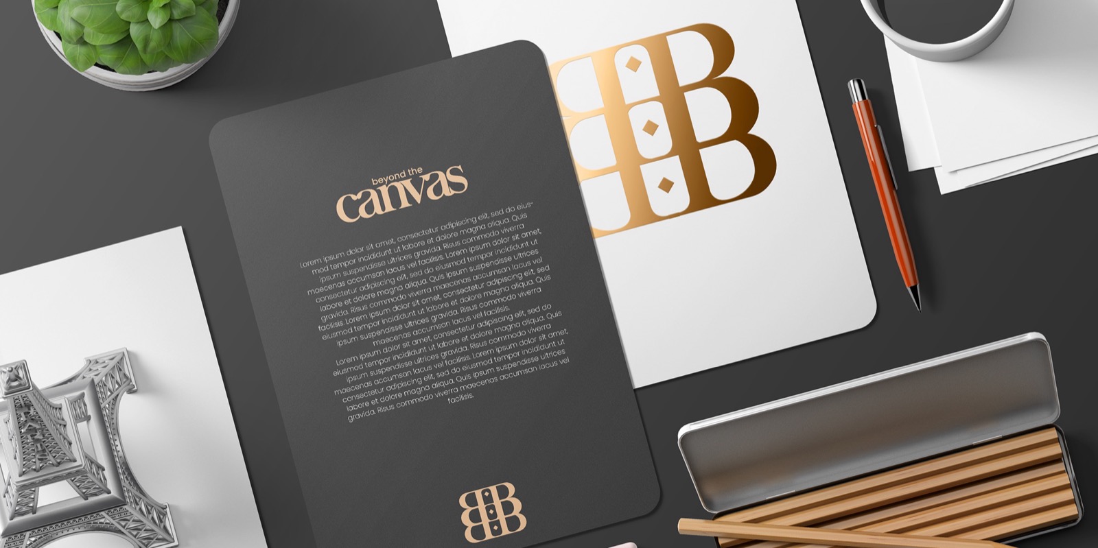 Beyond The Canvas stationery on a dark desk with the gold stacked B monogram